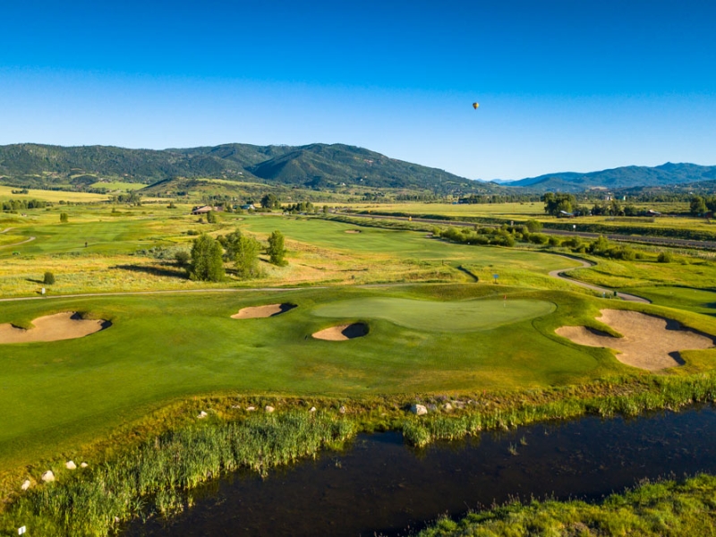 Golf hole with hot air balloon in background